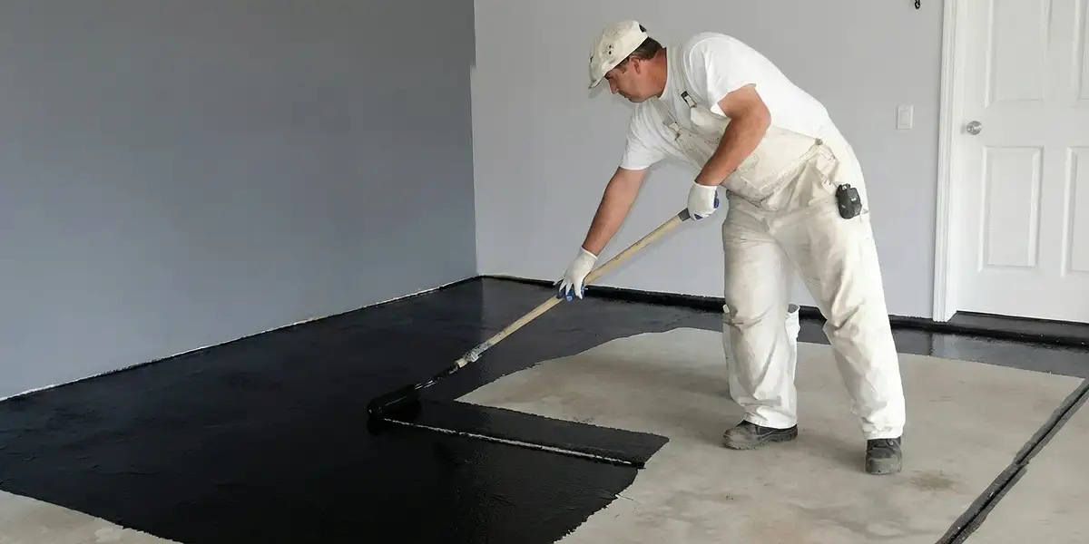 basement waterproofing professional applying waterproof coating to protect a basement floor in Chicago, IL